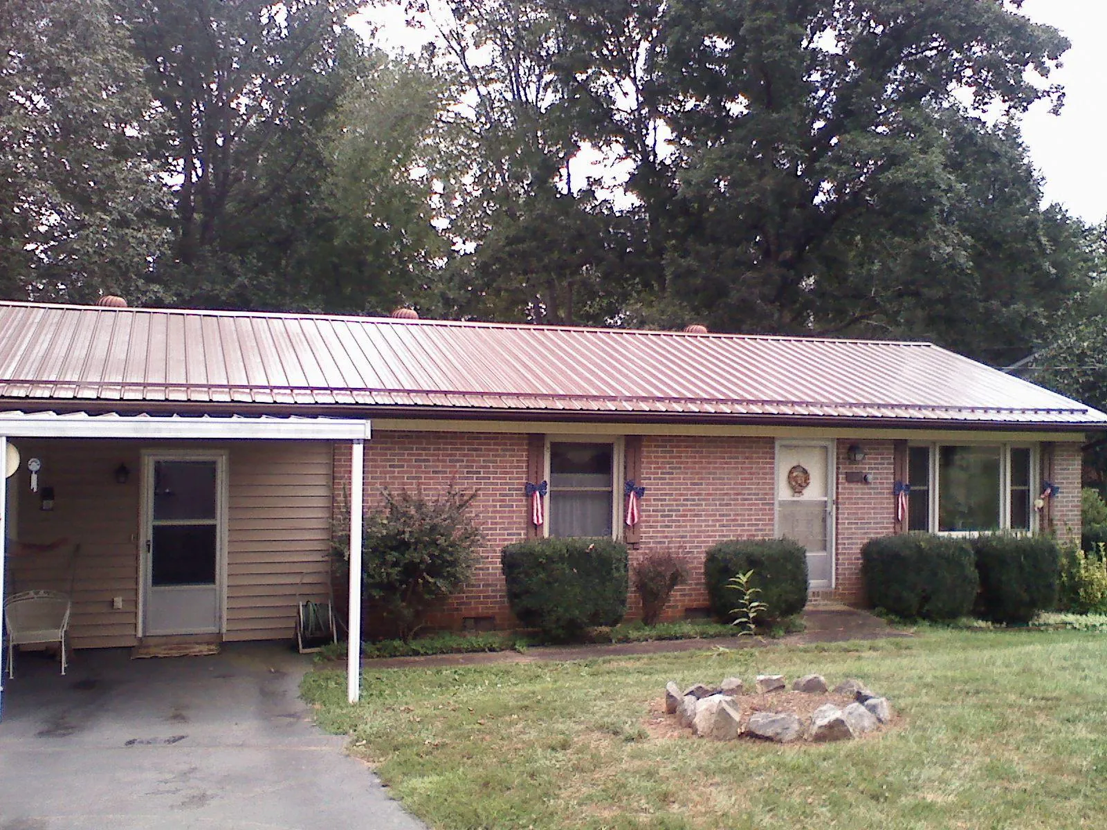 Bronze metal roof and carport on a brick ranch home — Roof Repair work by our crew in Humptulips